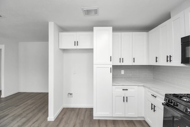 kitchen featuring light hardwood / wood-style flooring, light stone countertops, and white cabinets