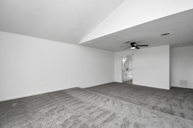 unfurnished living room with ceiling fan and dark colored carpet