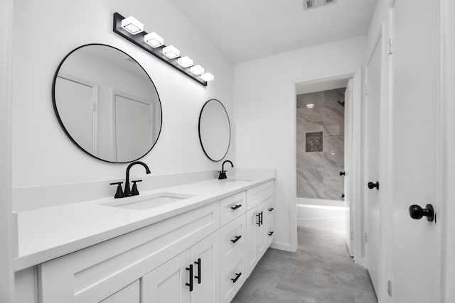 bathroom featuring vanity and tiled shower / bath