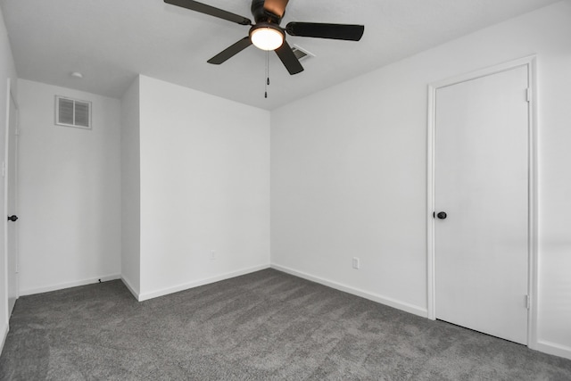 unfurnished room featuring dark colored carpet and ceiling fan