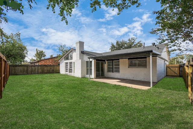 back of property featuring a patio and a yard