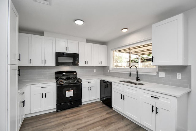 kitchen with white cabinets, decorative backsplash, black appliances, sink, and dark hardwood / wood-style floors