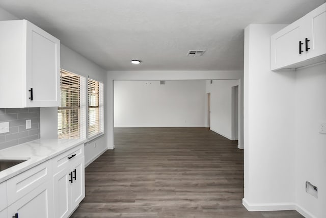 kitchen featuring white cabinetry, dark hardwood / wood-style floors, tasteful backsplash, and light stone countertops