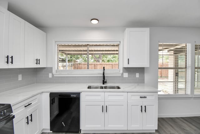 kitchen featuring white cabinets, hardwood / wood-style floors, black appliances, sink, and light stone countertops