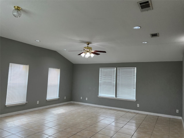 spare room with lofted ceiling, ceiling fan, and light tile patterned floors