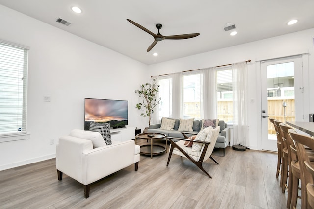 living room with ceiling fan and light hardwood / wood-style flooring