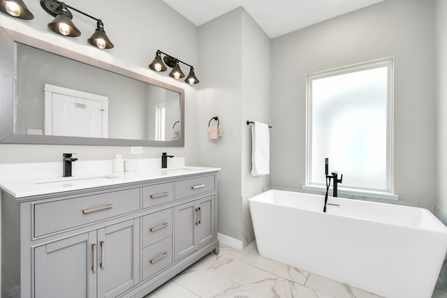 bathroom with vanity, a washtub, and a healthy amount of sunlight