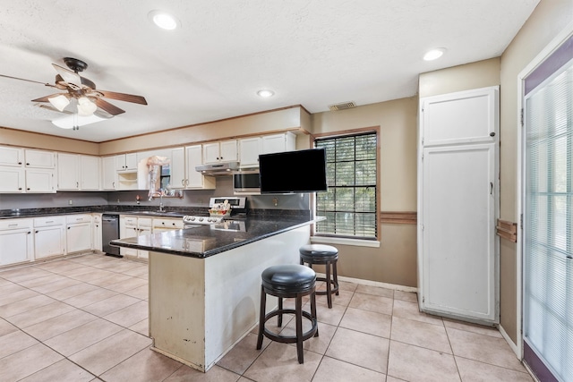 kitchen with white cabinets, light tile patterned floors, a breakfast bar area, and stainless steel range with electric cooktop