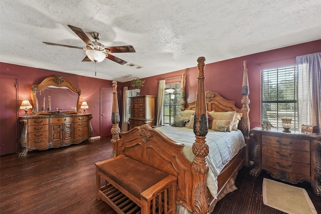 bedroom with a textured ceiling, dark wood-type flooring, and ceiling fan