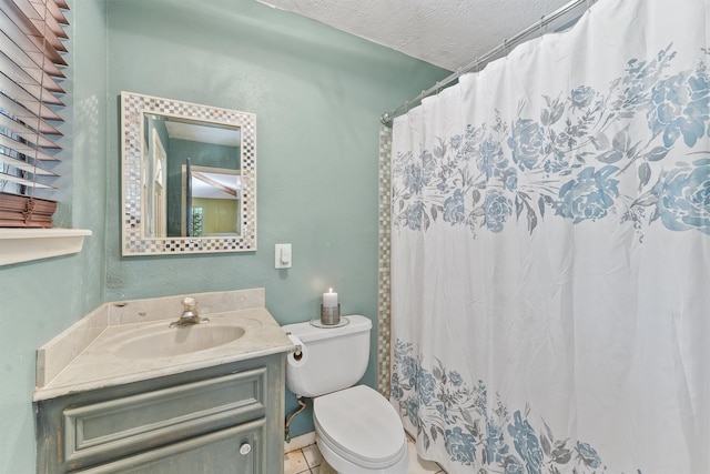 bathroom with a textured ceiling, toilet, tile patterned floors, walk in shower, and vanity