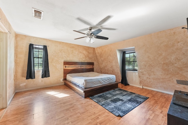 bedroom with light hardwood / wood-style floors, multiple windows, and ceiling fan