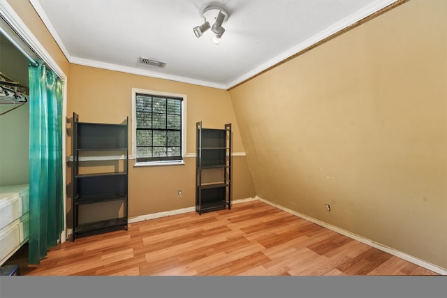 unfurnished bedroom with ornamental molding and light hardwood / wood-style flooring