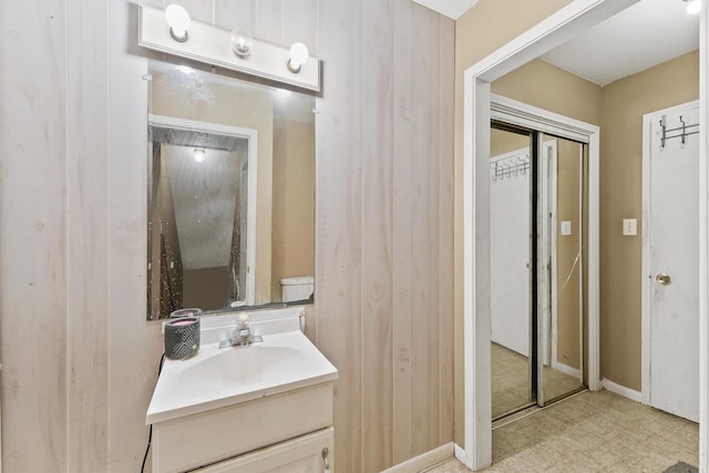 bathroom featuring vanity and wooden walls