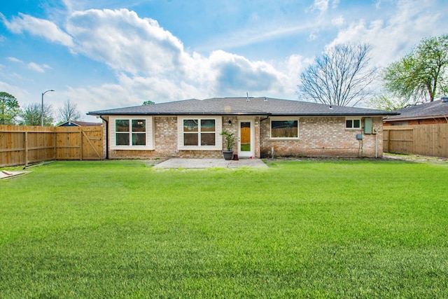 back of house featuring a lawn and a patio