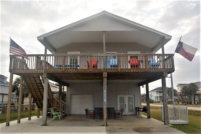 view of front of home featuring a carport, french doors, a garage, and a deck