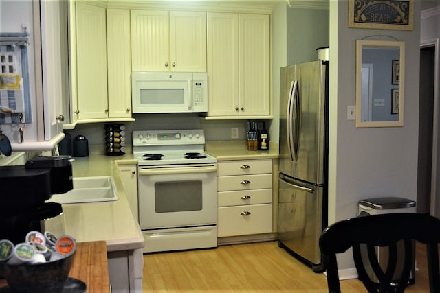 kitchen featuring crown molding, white appliances, and light wood-type flooring