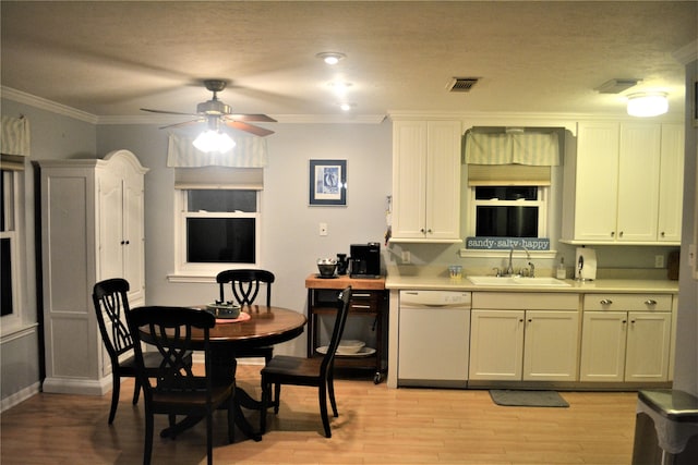 kitchen with dishwasher, crown molding, sink, ceiling fan, and light wood-type flooring