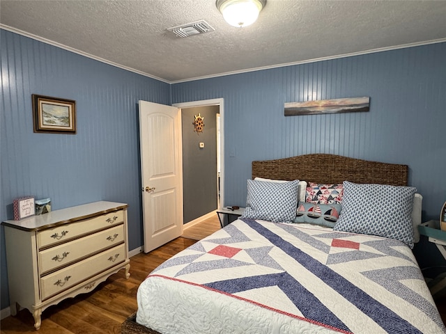 bedroom with a textured ceiling, ornamental molding, and dark hardwood / wood-style flooring