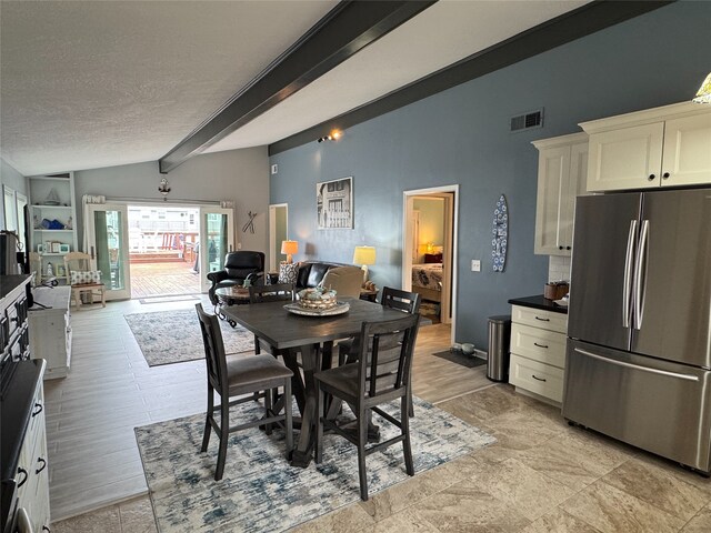 dining space featuring a textured ceiling and lofted ceiling with beams