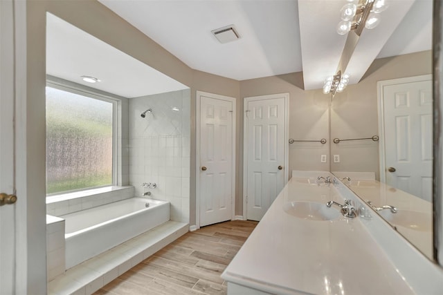 bathroom featuring vanity, plus walk in shower, and hardwood / wood-style floors