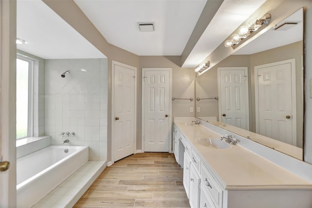 bathroom featuring vanity, hardwood / wood-style flooring, independent shower and bath, and a wealth of natural light