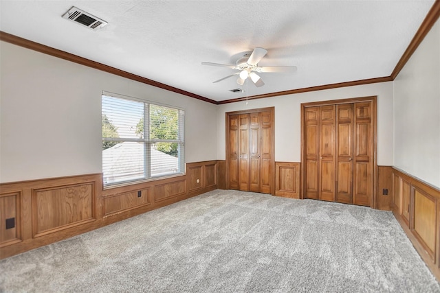 unfurnished bedroom featuring crown molding, light carpet, and ceiling fan