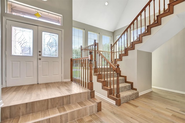 entrance foyer featuring high vaulted ceiling and wood-type flooring