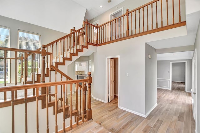 staircase featuring hardwood / wood-style flooring and a high ceiling