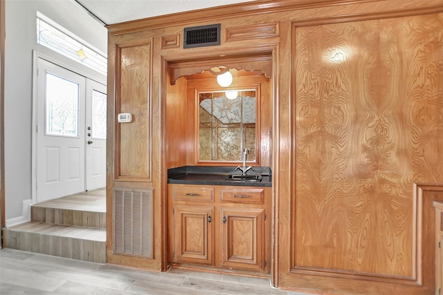 bar featuring light hardwood / wood-style floors and sink