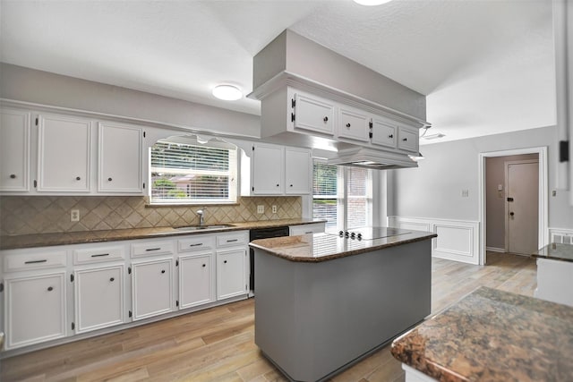 kitchen featuring light hardwood / wood-style floors, white cabinets, sink, and a kitchen island