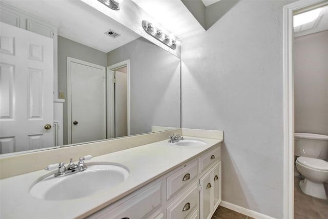 bathroom with vanity, toilet, and tile patterned flooring