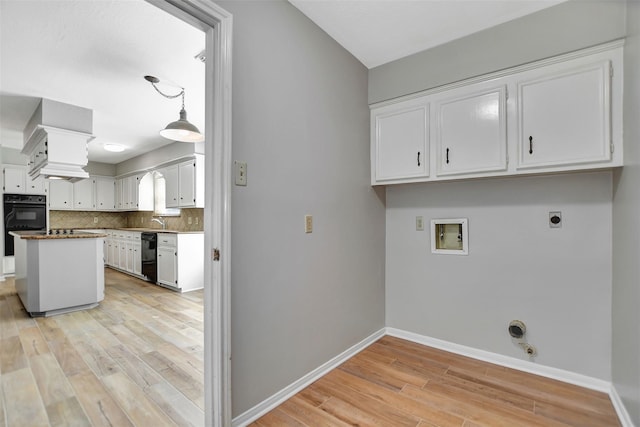 laundry room featuring gas dryer hookup, light hardwood / wood-style flooring, hookup for a washing machine, electric dryer hookup, and sink