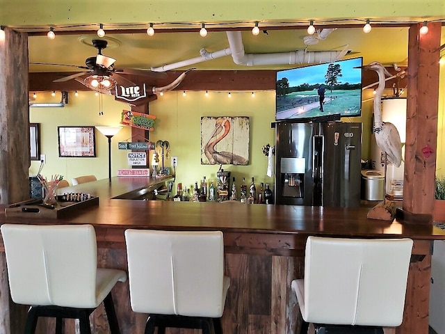 bar with ceiling fan, gas water heater, and stainless steel fridge