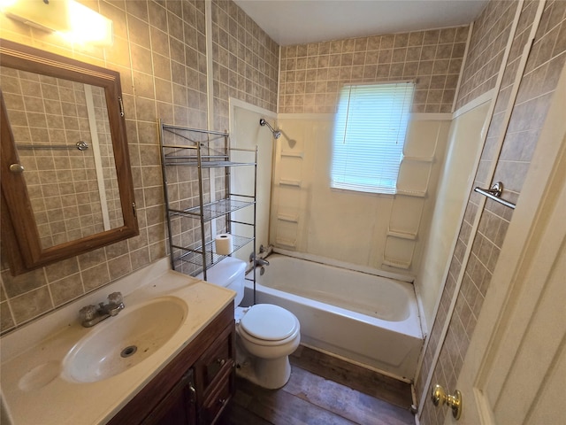 full bathroom featuring vanity, toilet, tile walls, and tiled shower / bath combo