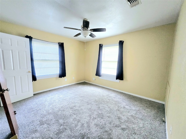 carpeted spare room with ceiling fan