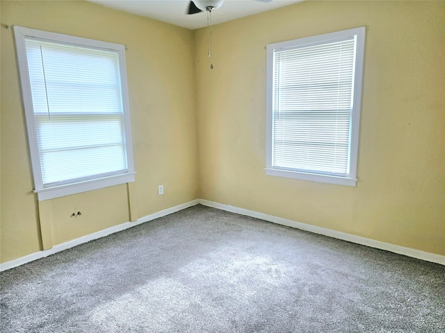 carpeted empty room with ceiling fan and plenty of natural light