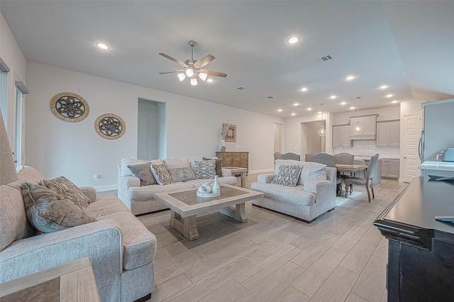 living room with light hardwood / wood-style flooring and ceiling fan