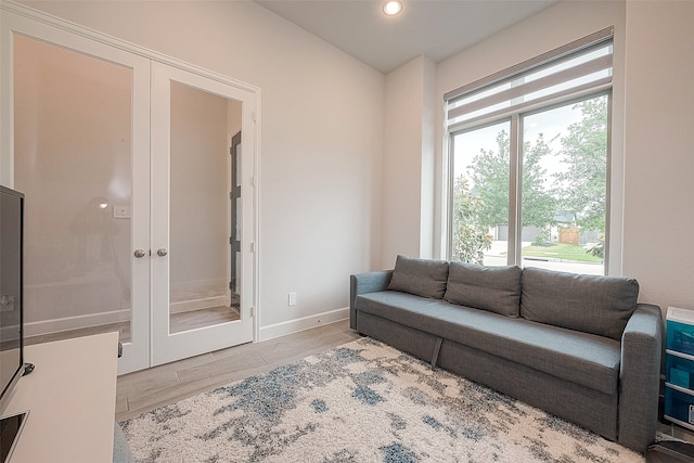 living room featuring french doors and light wood-type flooring