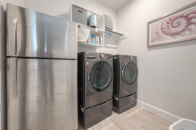 laundry room featuring light hardwood / wood-style flooring and separate washer and dryer