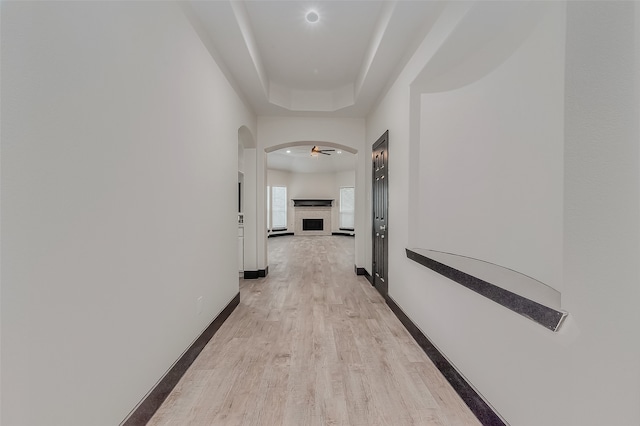 hall featuring light hardwood / wood-style flooring and a tray ceiling