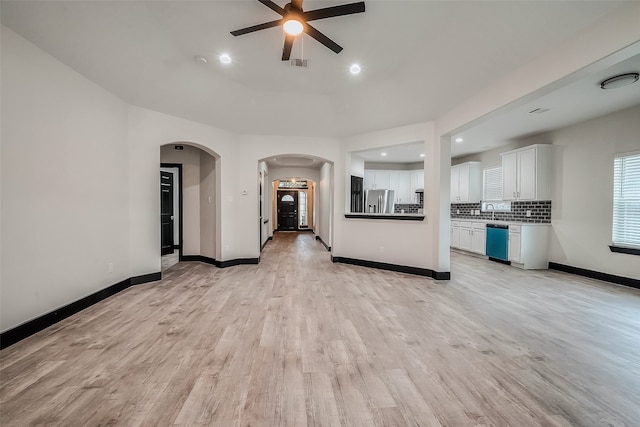 unfurnished living room with ceiling fan and light hardwood / wood-style flooring