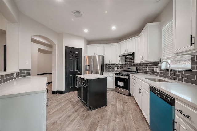 kitchen featuring stainless steel appliances, white cabinetry, sink, light hardwood / wood-style flooring, and a center island