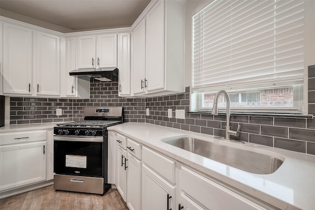 kitchen featuring white cabinetry, decorative backsplash, stainless steel gas stove, and sink