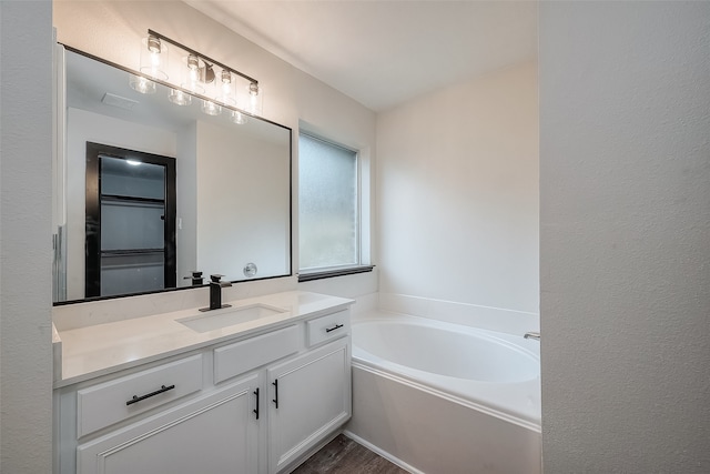 bathroom with a bathtub, vanity, and wood-type flooring