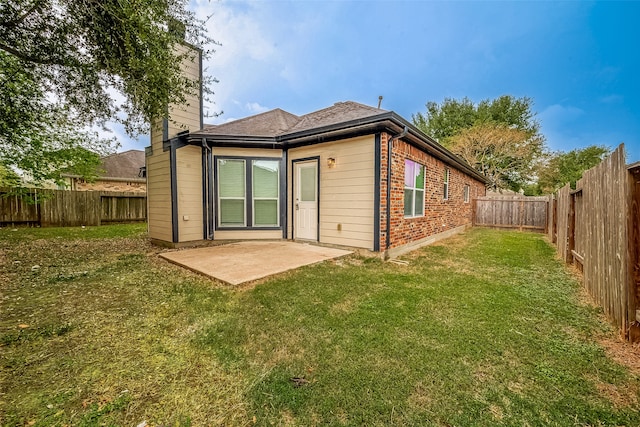 back of house with a patio area and a lawn