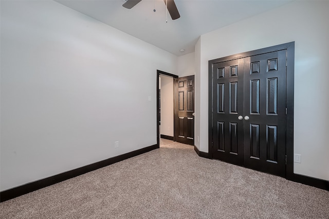 unfurnished bedroom featuring ceiling fan, a closet, and light colored carpet