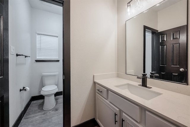 bathroom featuring vanity, toilet, and wood-type flooring