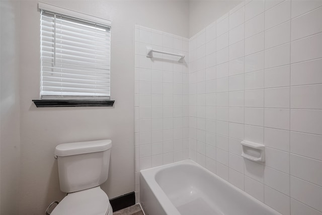 bathroom with toilet and tiled shower / bath combo