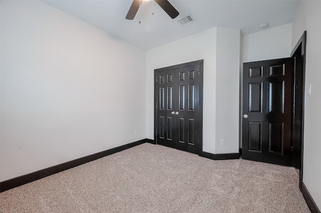 unfurnished bedroom featuring ceiling fan, a closet, and carpet floors