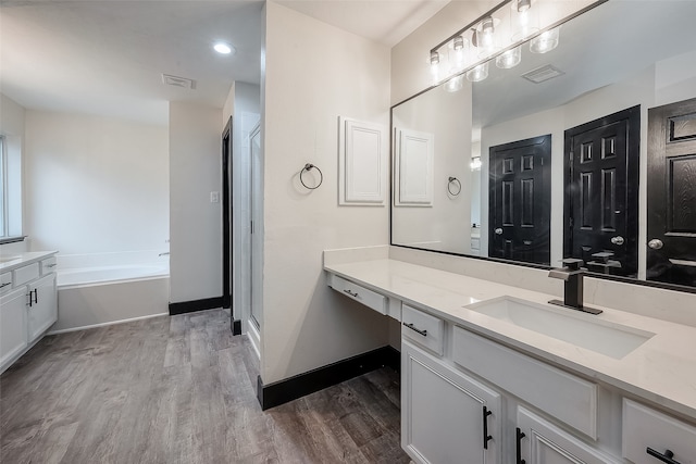 bathroom with hardwood / wood-style flooring, vanity, and separate shower and tub